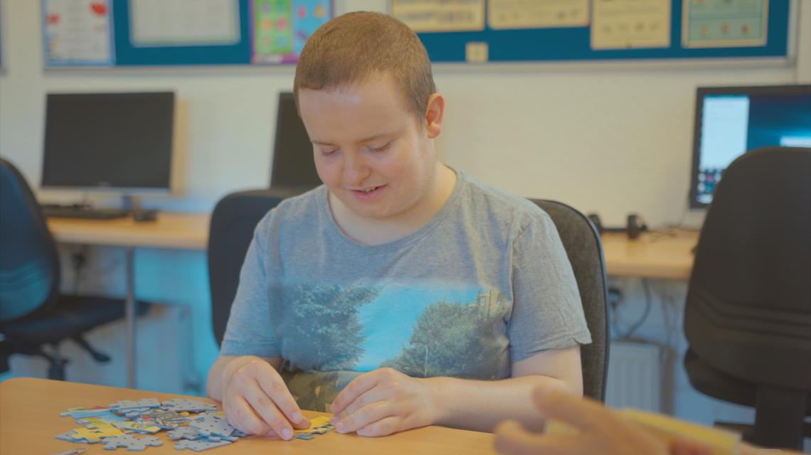 Boy doing jigsaw in computer room