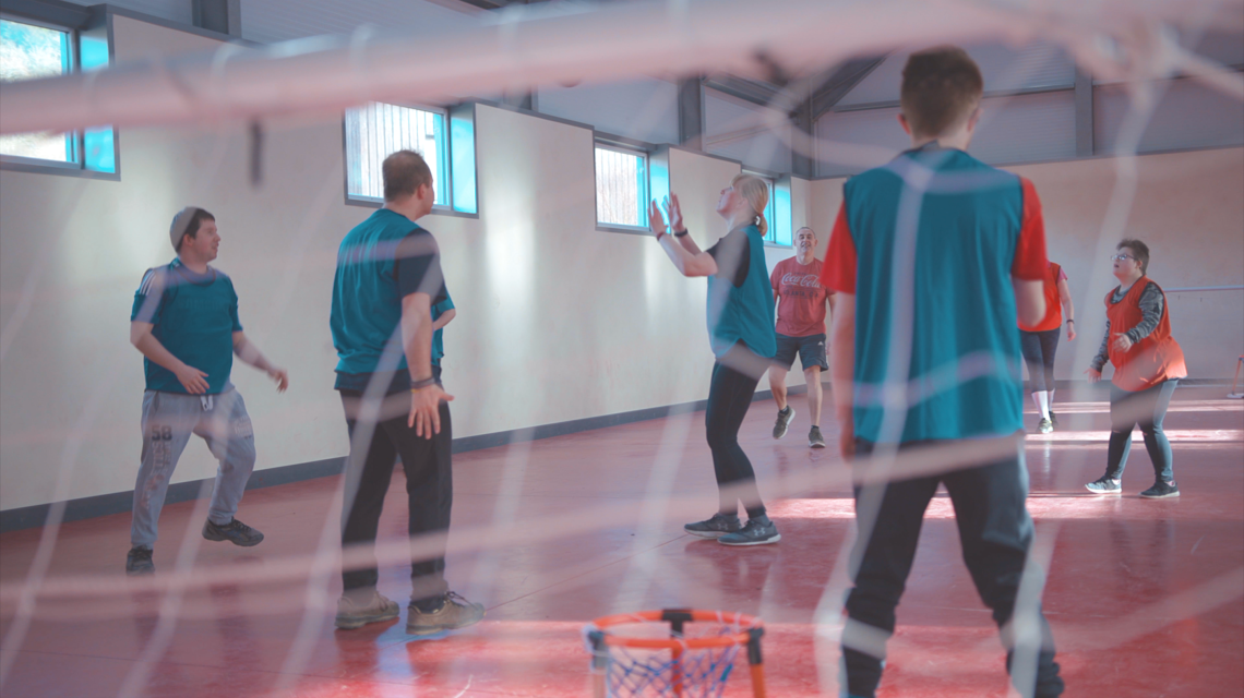 Group playing football in gym.